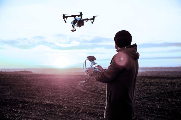 Hobbyist drone user flying on farmland